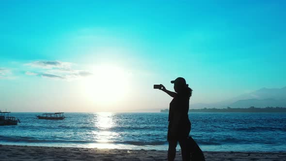 Young smiling lady on holiday by the sea on the beach on summer white sand and blue 4K background