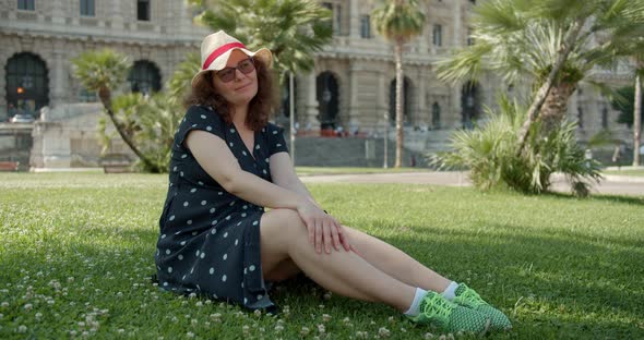 Young female sitting on the grass outdoors