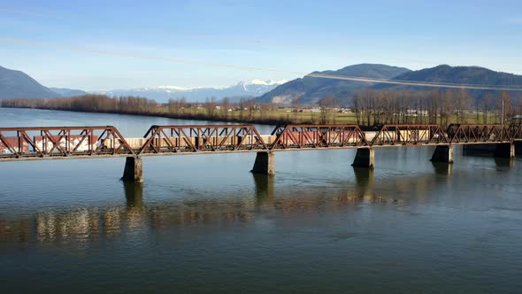 Freight Train Crossing On Mission Railway Bridge Over The Fraser River In Mission, BC, Canada. wide