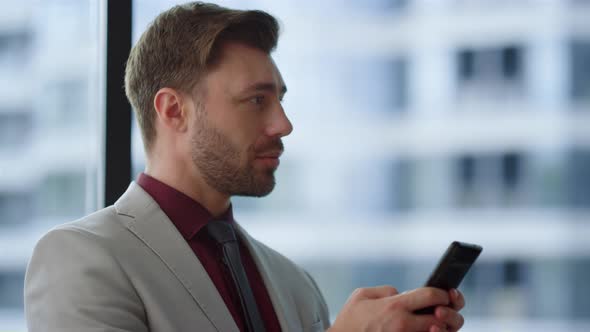 Focused Businessman Typing Phone Surfing Internet in Corporate Building Office