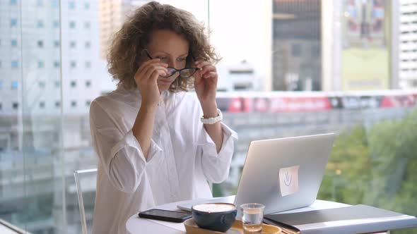 Young Business Woman Working On Laptop In Cafe Drinking Coffee