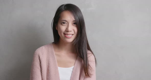 Asian woman smile to camera over gray background