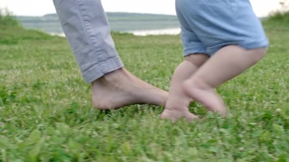 Woman Teaching Toddler to Walk alt