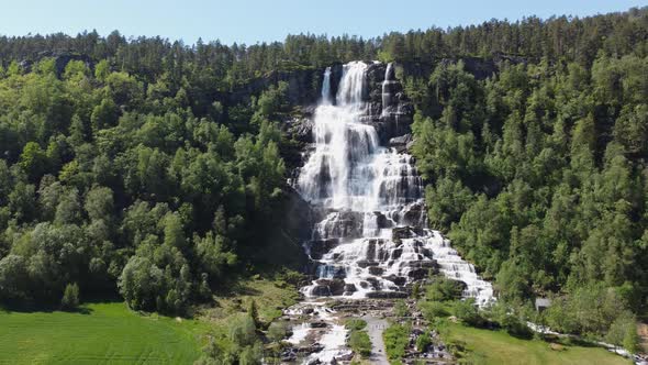 Distant upward moving aerial overview of Tvindefossen at Voss - Norway