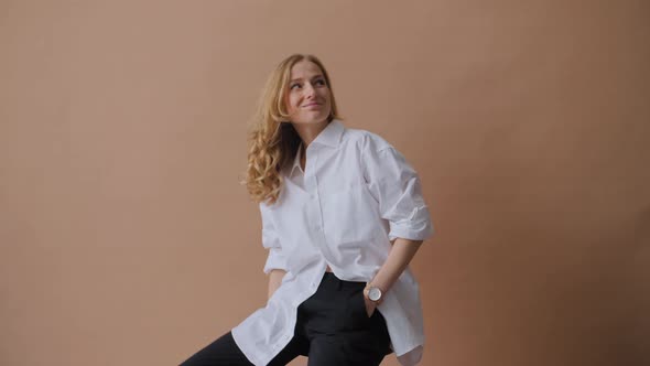 Elegant Professional Model in the White Shirt Posing to a Camera in the Studio