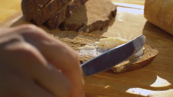 Hand smearing bread with butter