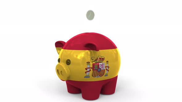 Coins Fall Into Piggy Bank Painted with Flag of Spain