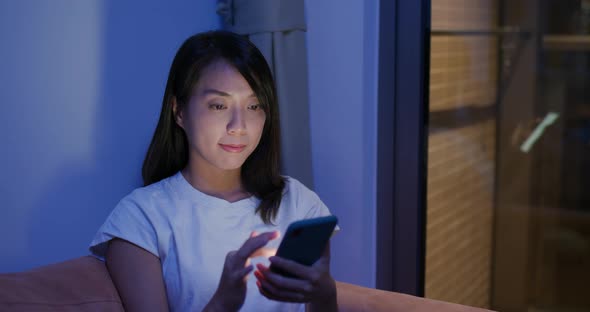 Woman use of cellphone at home in the evening