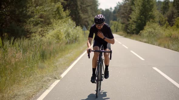 Cyclist Riding On Carbon Bike In Lycra Sportswear. Muscular Fitness Biker Cycling Workout.