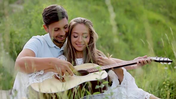 Couple In Love On Nature, Man Teaching Woman Playing In Guitar