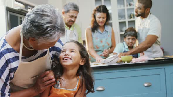 Girl interacting with granny while family preparing cookies 4k