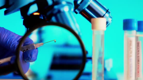 Doctor Holds Syringe with Ampoules Covid19 Vaccine on a Laboratory Bench