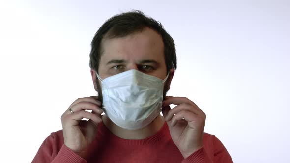 Man Removes Face Mask Under Remains One More. Protection of Coronavirus Concept