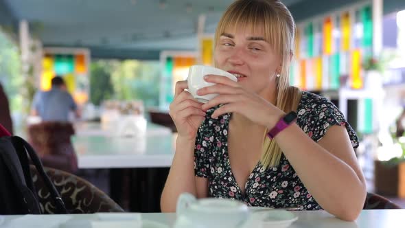 Happy Woman Drink Tea in a Cafe and Relaxing