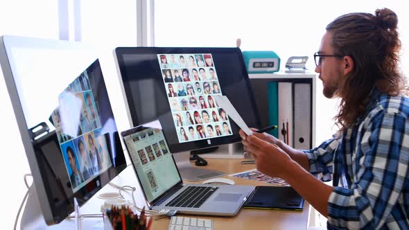 Male executive working over laptop and graphic tablet at his desk 4k