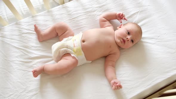 Cute Newborn Baby Lying on the Back in Child Crib