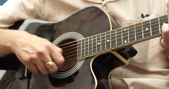 Close Up of Mans Hands Playing Acoustic Guitar