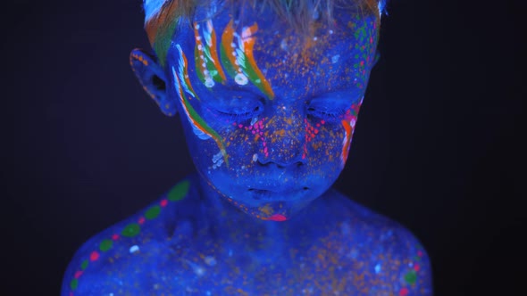 Closeup of a Small Boy's Face with an Ultraviolet Pattern on His Body and Face