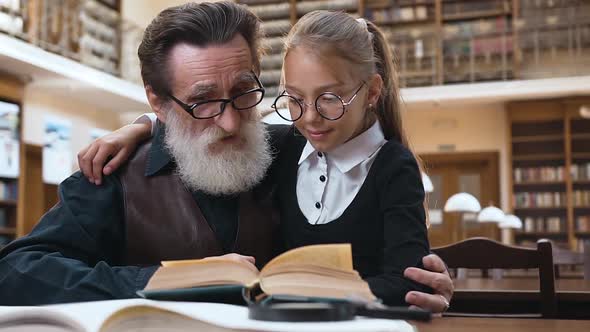 Lovely Pair of Granddaughter and Her Old Bearded Grandfather which Sitting in the Library