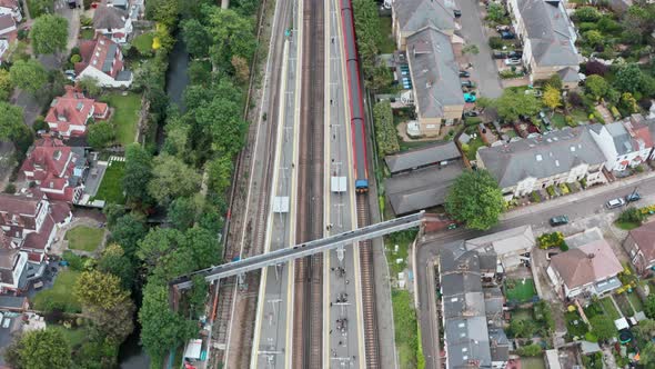 pan down Drone shot over South Western British Rail train arriving at Twickenham station