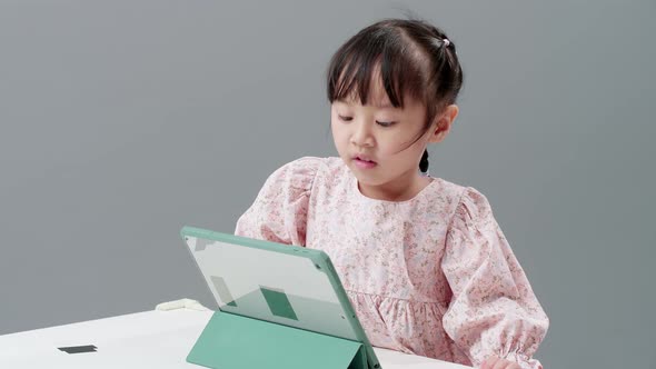 Child entertained with digital tablet on the table. Concept of use of technology in infarcient