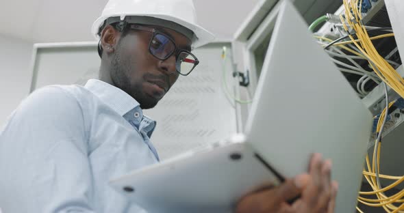 Man Using a Laptop While Working in a Server Room