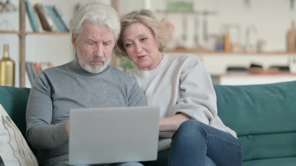 Old Couple Excited While Working on Laptop Home