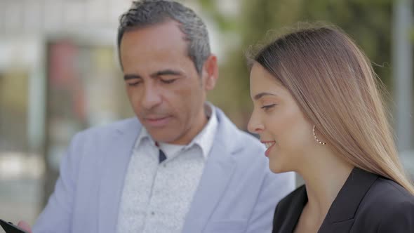 Smiling Man and Woman Using Tablet Pc on Street