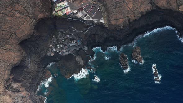 Aerial flat slider over volcanic ocean coast and small village, Hierro