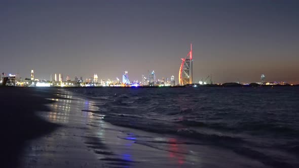 Burj Al Arab in Jumeirah Island or boat building with waves on sea beach, Dubai