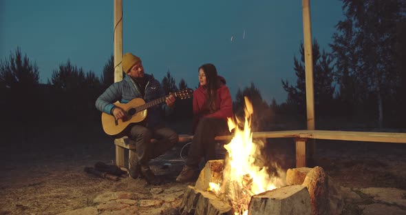 A Man Plays the Guitar for a Woman