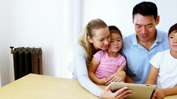 Happy family using digital tablet in living room