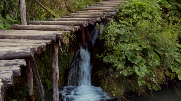 Young woman in shorts near the cascade of waterfalls