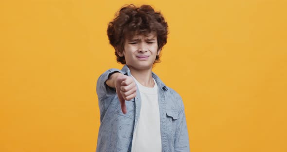 Dislike Gesture. Little Boy Showing Thumb Down and Shaking Head in Denial