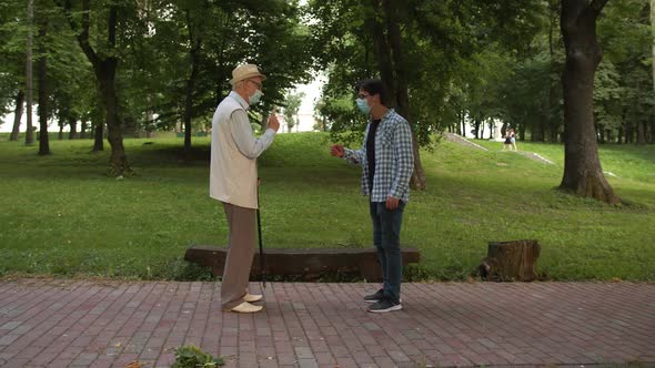 An Erderly Man Greets Elbows with His Young Friend