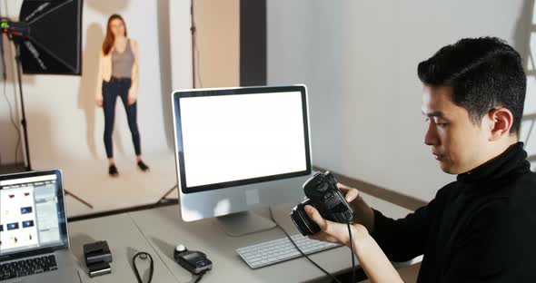 Photographer reviewing picture on digital camera during photo shoot