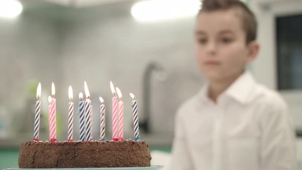 Boy Looking on Birthday Cake with Candle Flames