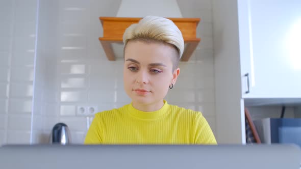 Young adult female working freelance on notebook computer at home during lockdown in 4k video