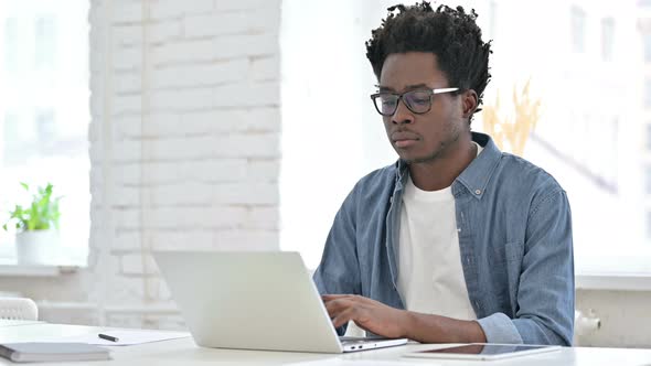Young African Man Working on Laptop 