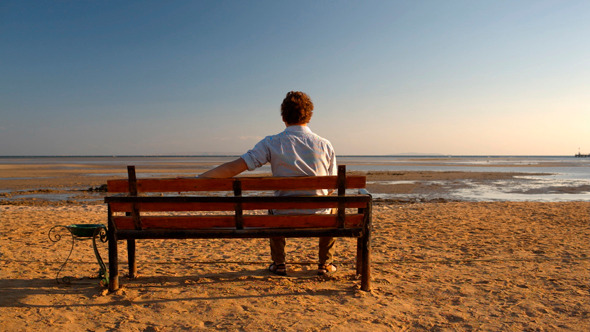 Man Sitting Alone on  Beach