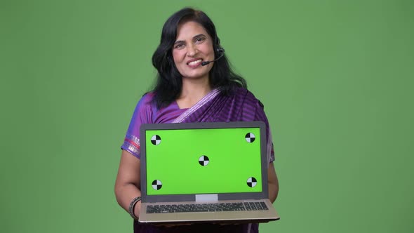 Mature Happy Beautiful Indian Woman As Call Center Representative Talking While Showing Laptop