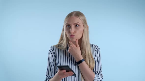 Smart Young Woman Looking at Smartphone and Start Planning Something on Blue Background