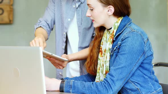 Business executives discussing over digital tablet