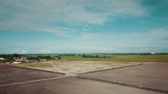 Aerial drone shot flying over dry empty farmer's field in rural South America