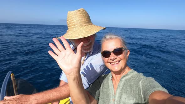 Beautiful and cute couple of seniors or old people in the middle of the sea driving and discovering
