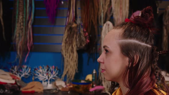 Unrecognizable Person Makes Hairstyle for Young Woman in Salon