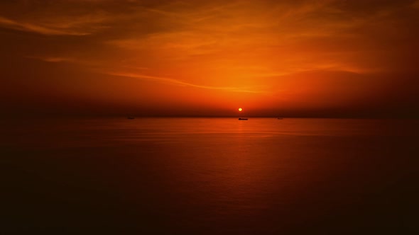 Ships in the sea against the backdrop of an orange sunset