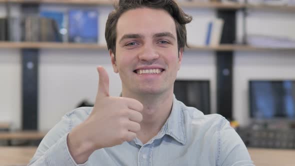 Thumbs Up By Creative Man Looking at Camera at Work