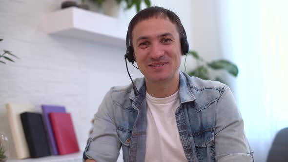 Head Shot Millennial Guy Sit in Living Room Makes Video Call Looks at Camera