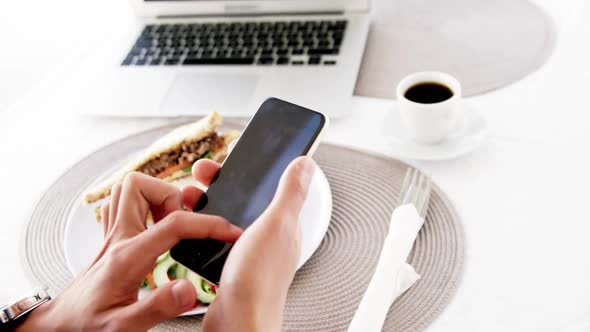 video of man using smartphone with lunch